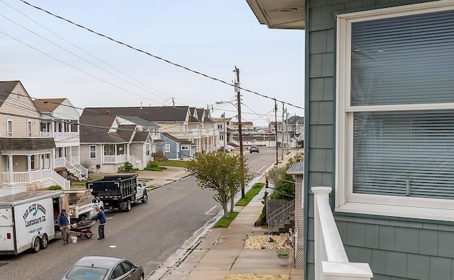 view of road with a residential view, sidewalks, and curbs