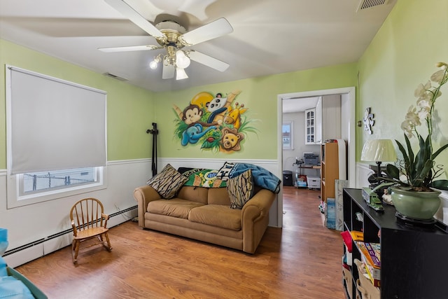 living room with wainscoting, wood finished floors, and visible vents
