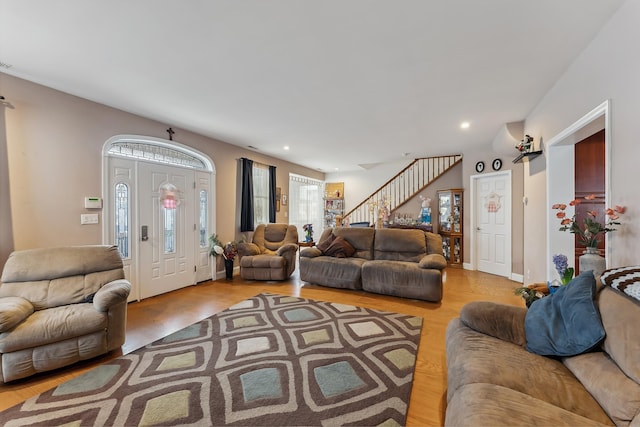 living room featuring wood finished floors, stairs, visible vents, and recessed lighting
