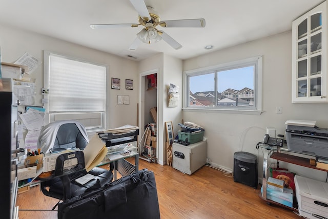 office space featuring ceiling fan, visible vents, and light wood-type flooring