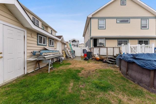 rear view of house featuring fence and a yard