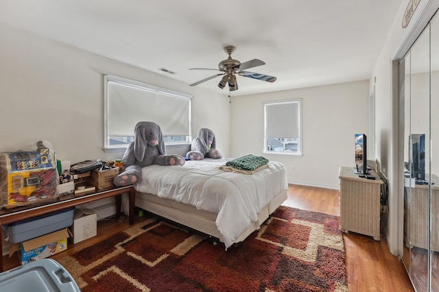 bedroom with light wood-type flooring, visible vents, a closet, and multiple windows