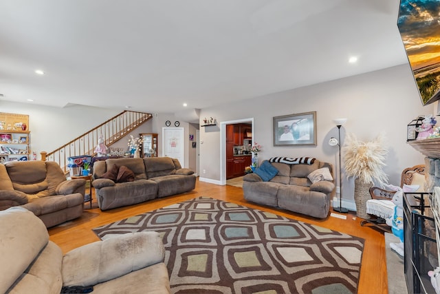 living room with baseboard heating, wood finished floors, recessed lighting, and stairs