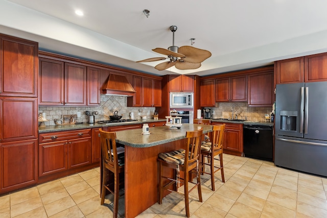 kitchen featuring dark countertops, dark brown cabinets, tasteful backsplash, stainless steel appliances, and custom range hood
