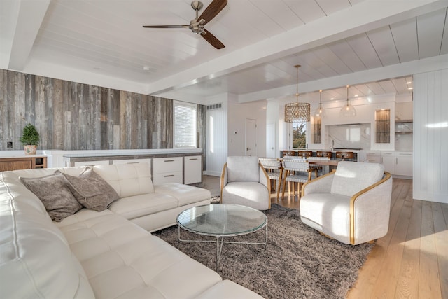 101 Harvard Ave, Cape May Point, NJ 08212 - living room featuring light wood-type flooring, beamed ceiling, ceiling fan with notable chandelier, wood walls, and wood ceiling