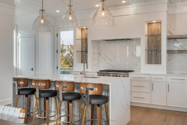 101 Harvard Ave, Cape May Point, NJ 08212 - kitchen with a kitchen island with sink, light wood-style flooring, a sink, tasteful backsplash, and white cabinets