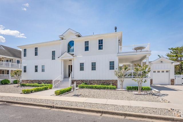 264 41st St, Avalon, NJ 08202 - view of front facade with board and batten siding, a garage, a balcony, driveway, and a porch