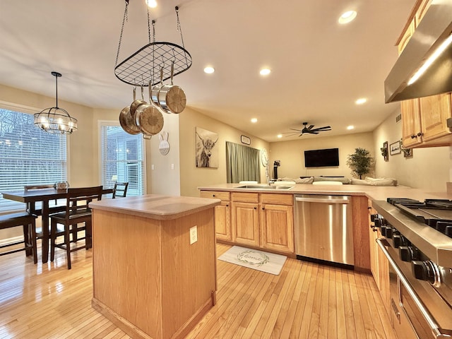 kitchen featuring a sink, under cabinet range hood, dishwasher, and light brown cabinetry