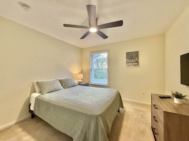 bedroom featuring a ceiling fan, light colored carpet, and baseboards