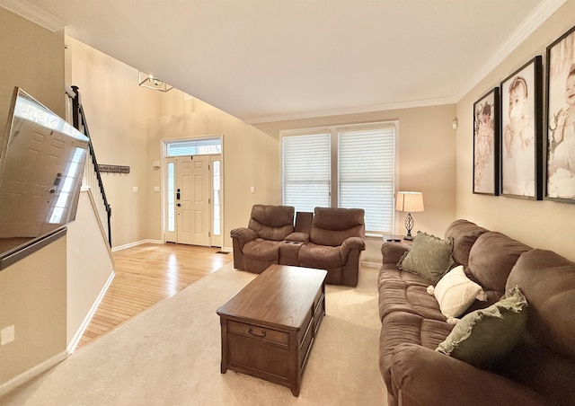 living room featuring ornamental molding, light carpet, light wood-style flooring, and baseboards