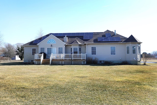 exterior space featuring a deck, a front yard, and solar panels