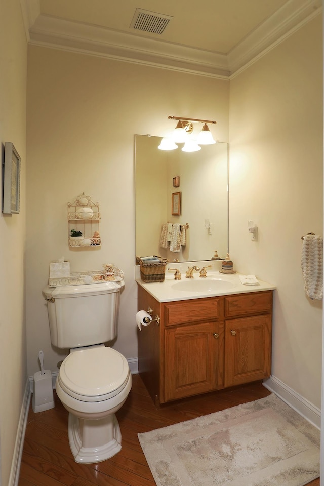 bathroom with hardwood / wood-style flooring, ornamental molding, toilet, and vanity