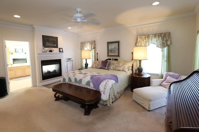 carpeted bedroom featuring crown molding, a multi sided fireplace, connected bathroom, and ceiling fan