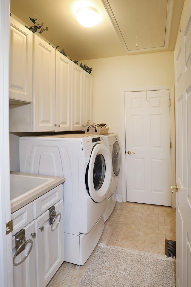 laundry area featuring cabinets, separate washer and dryer, sink, and light tile patterned floors