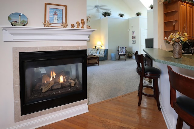 interior space with hardwood / wood-style flooring, a multi sided fireplace, and ceiling fan