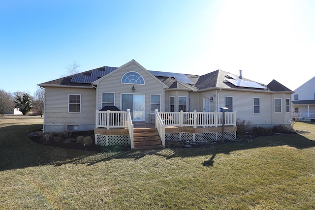 back of house featuring a lawn, solar panels, and a deck