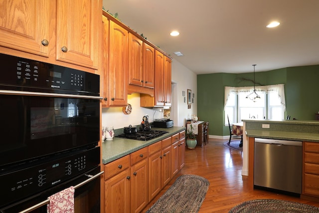 kitchen with pendant lighting, hardwood / wood-style floors, and black appliances