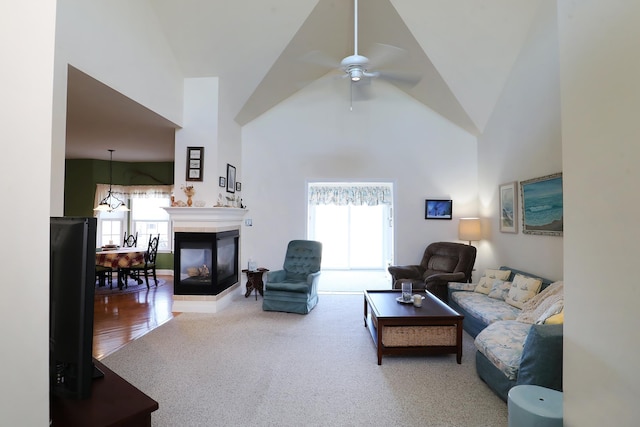 carpeted living room featuring ceiling fan, a multi sided fireplace, and high vaulted ceiling