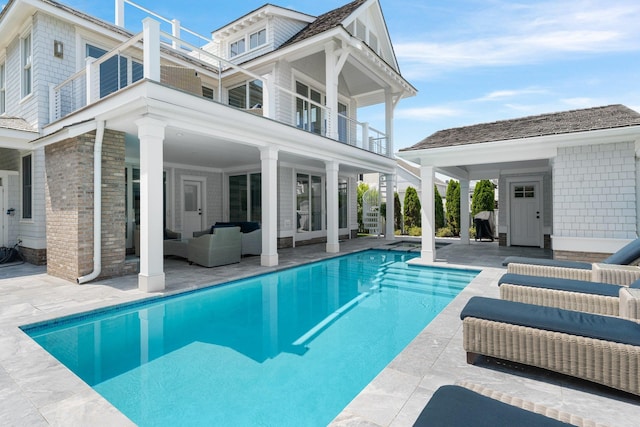 outdoor pool with an outdoor hangout area and a patio area