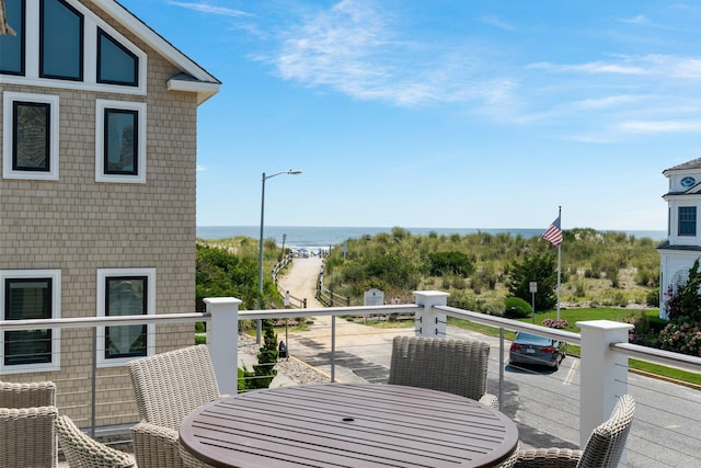 balcony featuring outdoor dining area and a water view