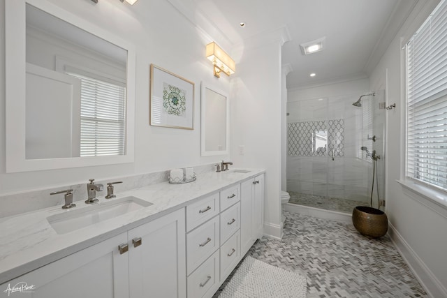 full bathroom featuring a sink, double vanity, a stall shower, and crown molding