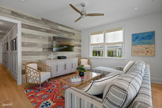 living area featuring recessed lighting, light wood-style floors, wood walls, and an accent wall