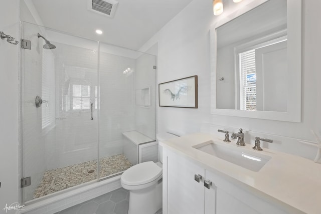 bathroom featuring visible vents, toilet, a stall shower, plenty of natural light, and vanity