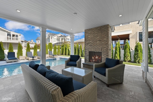 view of patio with a fenced in pool, a residential view, and an outdoor living space with a fireplace