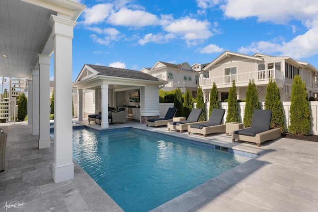 outdoor pool featuring a patio and fence