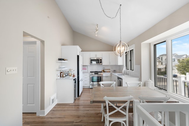 255 117th St Unit 2, Stone Harbor, NJ 08247 - dining area featuring an inviting chandelier, light wood-style flooring, visible vents, and high vaulted ceiling