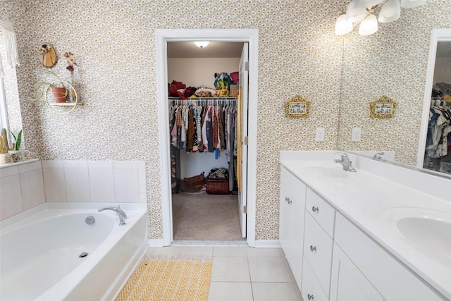 bathroom featuring tile patterned flooring, a bath, and vanity