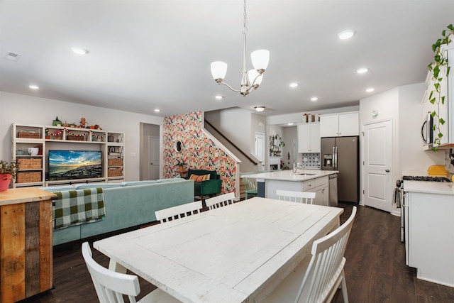 dining room featuring a fireplace, dark hardwood / wood-style flooring, an inviting chandelier, and sink