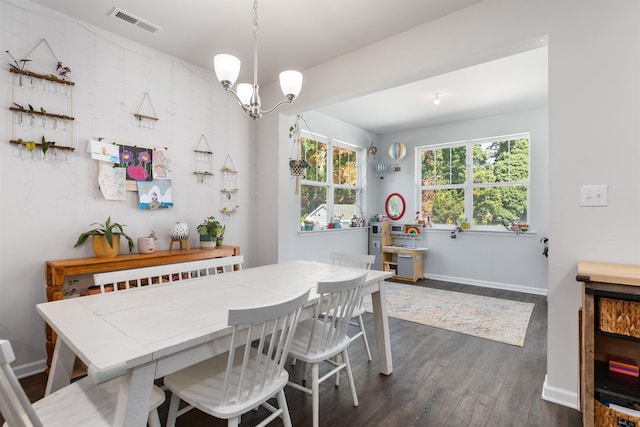 dining space featuring dark wood-type flooring and a chandelier