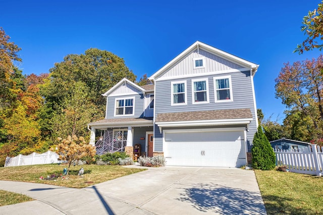 view of front of house with covered porch, a garage, and a front lawn