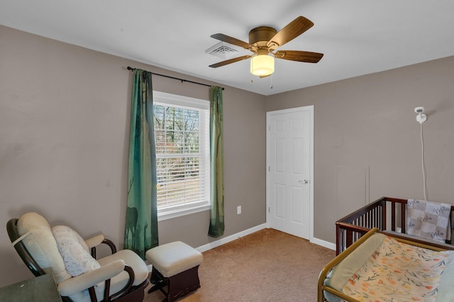 bedroom featuring carpet, visible vents, baseboards, ceiling fan, and a nursery area