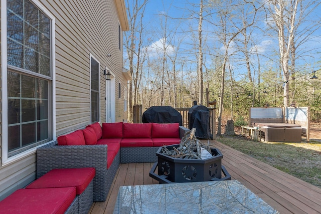 wooden terrace with area for grilling, an outdoor living space with a fire pit, and a hot tub