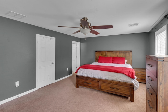 bedroom with visible vents, baseboards, light colored carpet, and a ceiling fan