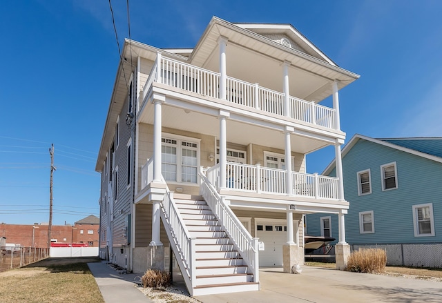 view of front facade featuring stairway, covered porch, concrete driveway, and a garage