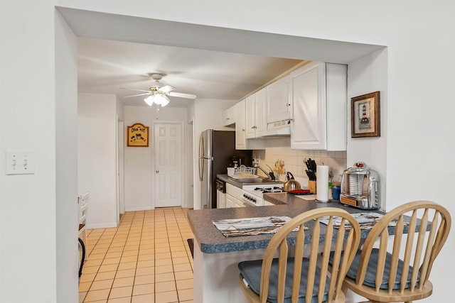 117 W Drumbed Rd, Villas, NJ 08251 - kitchen featuring dark countertops, backsplash, white cabinetry, a ceiling fan, and under cabinet range hood