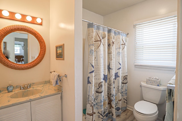 bathroom featuring toilet, hardwood / wood-style flooring, curtained shower, and vanity