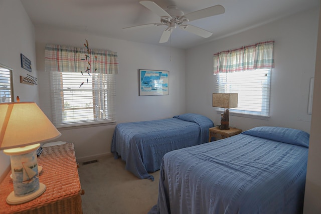 carpeted bedroom with ceiling fan and multiple windows