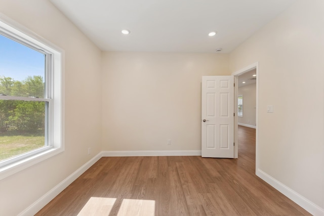 spare room featuring light wood-style floors, recessed lighting, baseboards, and a wealth of natural light