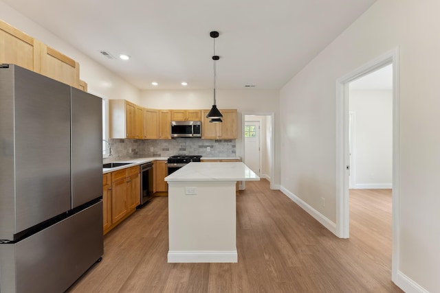 kitchen featuring light countertops, decorative backsplash, appliances with stainless steel finishes, and light wood-style flooring