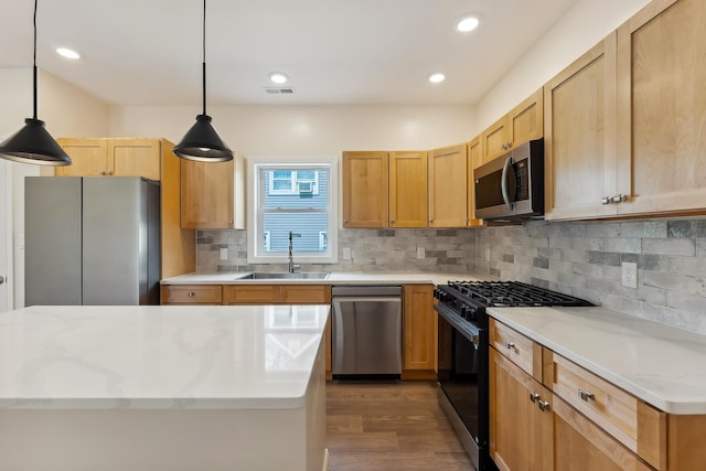 kitchen featuring a sink, stainless steel appliances, dark wood-type flooring, backsplash, and pendant lighting