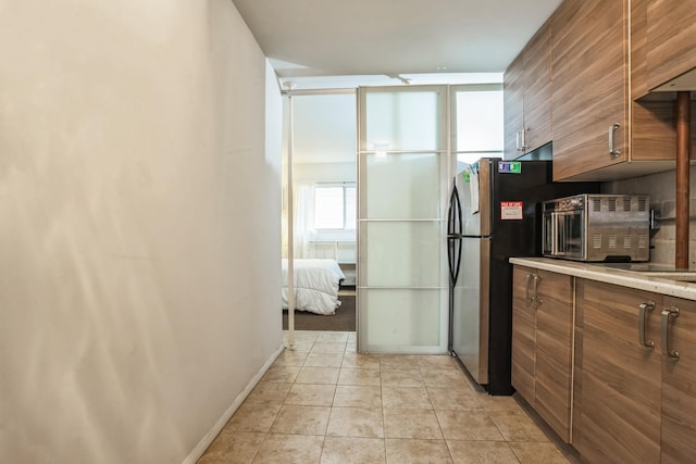 kitchen with refrigerator and light tile patterned floors