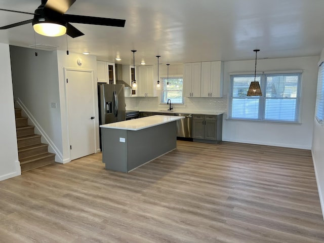 kitchen featuring sink, decorative backsplash, hanging light fixtures, a center island, and stainless steel appliances