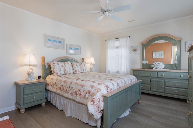 bedroom with dark hardwood / wood-style flooring, crown molding, and ceiling fan