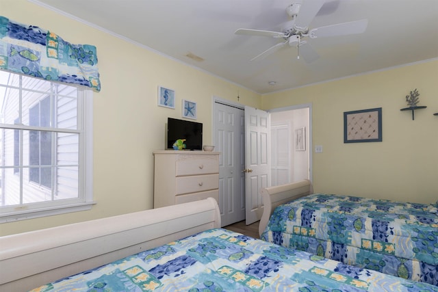 bedroom with ceiling fan, ornamental molding, hardwood / wood-style floors, and multiple windows