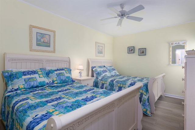 bedroom featuring crown molding, light hardwood / wood-style floors, and ceiling fan