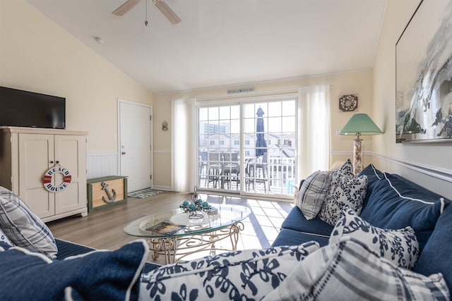 living room featuring vaulted ceiling, ceiling fan, and light hardwood / wood-style flooring